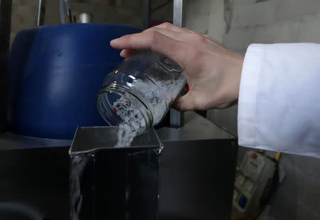 Christofer Costes, a French inventor who created a machine that turns plastic waste into fuel pours pieces of plastic in his invention in Puget-Theniers, France, December 14, 2018. Picture taken December 14, 2018. REUTERS/Eric Gaillard