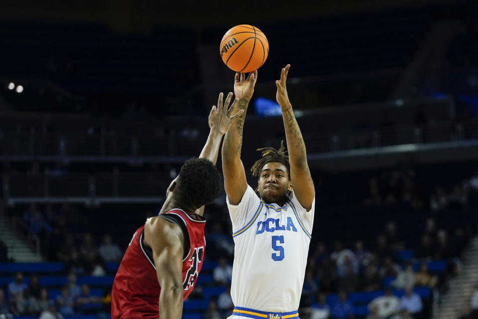 UCLA guard Brandon Williams, right, shoots as St. Francis forward Gestin Liberis defends during the first half of an NCAA college basketball game, Monday, Nov. 6, 2023, in Los Angeles. (AP Photo/Ryan Sun)