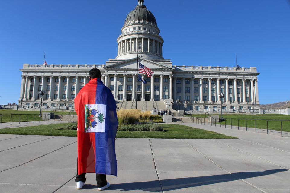 A supporter of Haitian immigrant rights draped in the Caribbean country’s flag stands in front of the Utah Capitol on Friday, Sept. 24. (Enrique Limón)