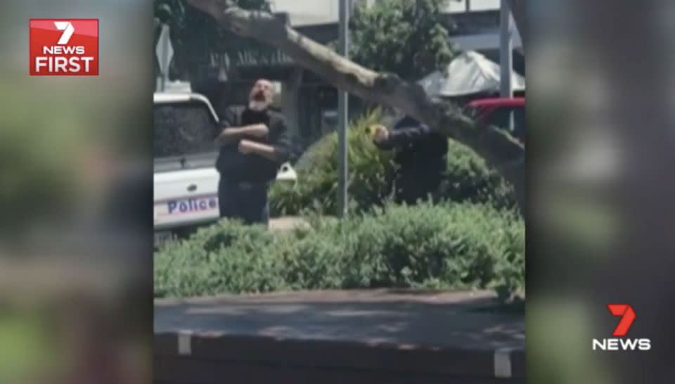 The police officer fires his taser. Source: 7 News