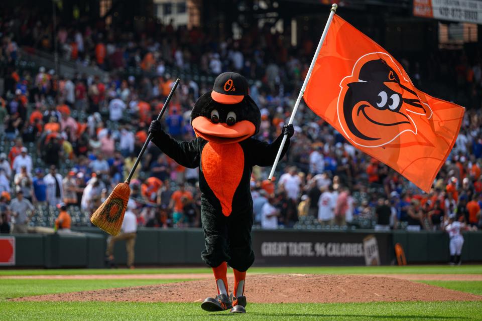 Orioles mascot waves a flag and broom after a win against the Mets at Oriole Park at Camden Yards.