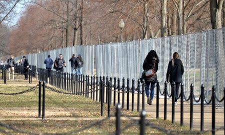 Tourists and visitors walk along a chain link fence constructed as a security measure on The Mall, in the days prior to Donald J. Trump's inauguration, in Washington, U.S., January 15, 2017. REUTERS/Mike Theiler