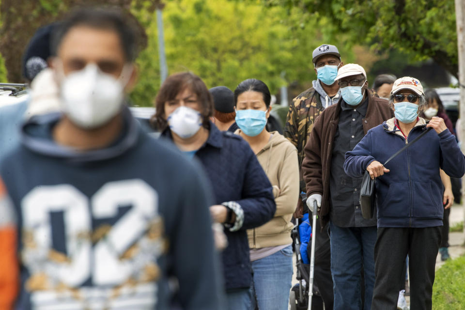 Residents of the Kew Gardens Hills neighborhood of the Queens borough of New York line up for free face mask the New York City Department of Parks & Recreation staff distributes the at the Mauro playground, Tuesday, May 5, 2020. New York City will distribute 100,000 face coverings in parks across the five boroughs to help protect against the coronavirus.The new coronavirus causes mild or moderate symptoms for most people, but for some, especially older adults and people with existing health problems, it can cause more severe illness or death. (AP Photo/Mary Altaffer)