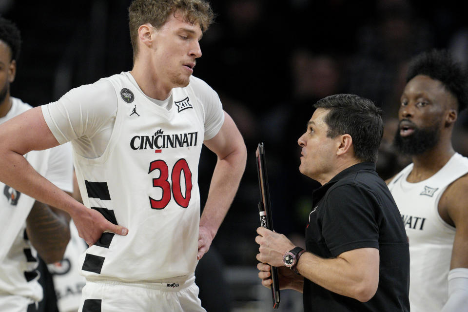 Cincinnati head coach Wes Miller, center right, speaks with Viktor Lakhin (30) during the first half of an NCAA college basketball game against Iowa State, Tuesday, Feb. 13, 2024, in Cincinnati. (AP Photo/Jeff Dean)