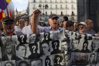 <p>Pro-referendum demonstrators shout slogans and hold a banner with portraits of Franco’s regime victims during a protest in support of Catalan’s referendum and against government repression. (Getty) </p>