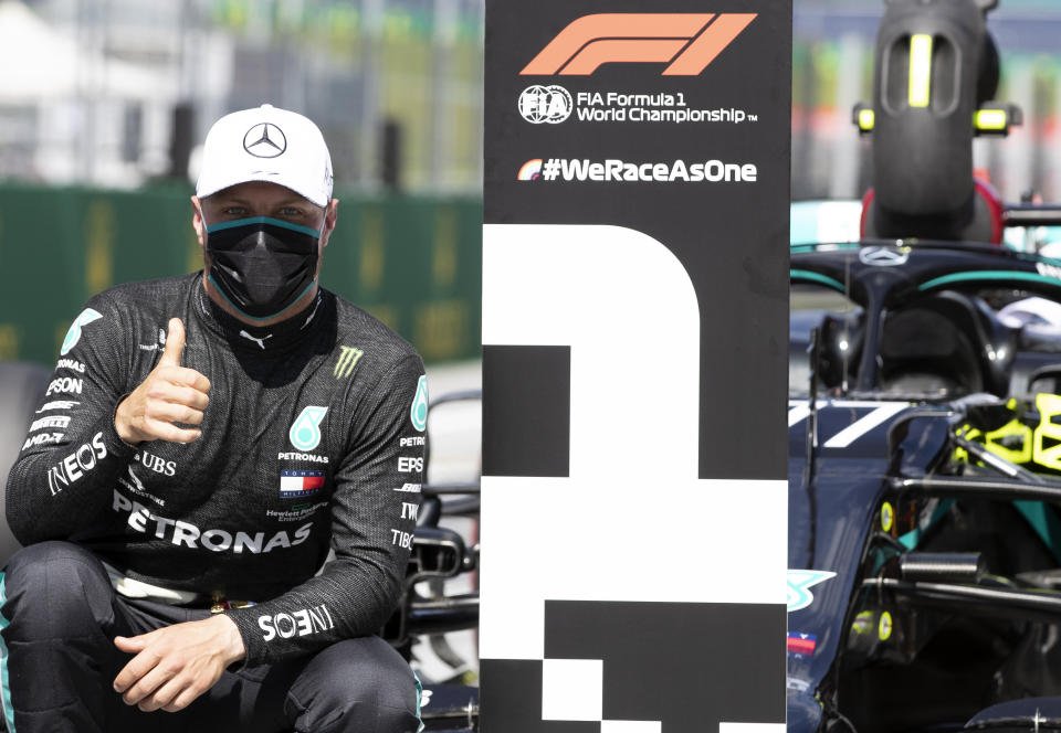 Mercedes driver Valtteri Bottas of Finland, wearing a mask against the spread of the coronavirus, poses after he clocked the fastest time during the qualifying session at the Red Bull Ring racetrack in Spielberg, Austria, Saturday, July 4, 2020. The Austrian Formula One Grand Prix will be held on Sunday. (Mark Thompson/Pool via AP)