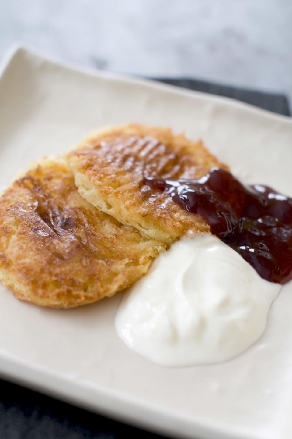 This Jan. 6, 2014 photo shows lemon syrniki in Concord, N.H. Syrniki is a farm-style cheese pancake, sort of a cross between cheesecake and pancakes. It can be served for breakfast, tea, a light meal or a snack. (AP Photo/Matthew Mead)