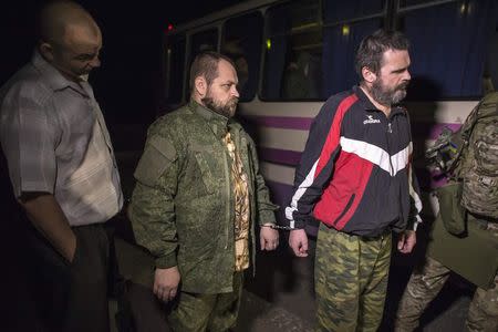 Members of the pro-Russian rebels (R and C), who are prisoners-of-war (POWs), stand by the side of a road as they wait to be exchanged, north of Donetsk, eastern Ukraine, September 12, 2014. REUTERS/Marko Djurica