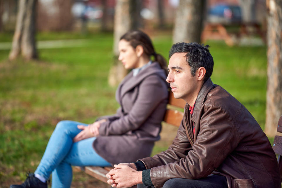 people sitting apart from each other on a bench