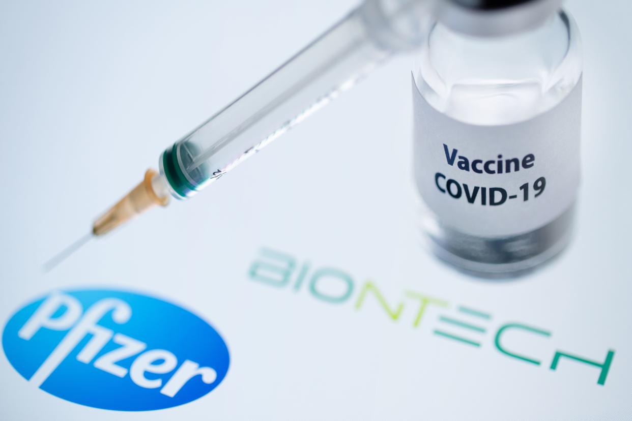 This illustration picture taken on November 23, 2020 shows a bottle reading "Vaccine Covid-19" and a syringe next to the Pfizer and Biontech logo. - The European Commission has signed five contracts to pre-order vaccines, among which with the U.S.-German company Pfizer-BioNTech (up to 300 million doses). (Photo by JOEL SAGET / AFP) (Photo by JOEL SAGET/AFP via Getty Images)