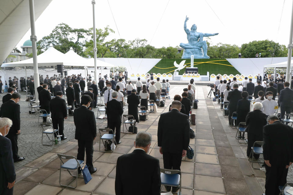 Attendees offer a silent prayer for the victims of the U.S. atomic bombing at the time when the bomb was dropped, during a ceremony at Nagasaki Peace Park in Nagasaki, southern Japan Monday, Aug. 9, 2021. The Japanese city of Nagasaki on Monday marked its 76th anniversary of the U.S. atomic bombing. (Kyodo News via AP)