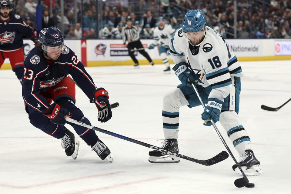 San Jose Sharks forward Filip Zadina (18) controls the puck in front of Columbus Blue Jackets defenseman Jake Christiansen (23) during the first period of an NHL hockey game in Columbus, Ohio, Saturday, March 16, 2024. (AP Photo/Paul Vernon)