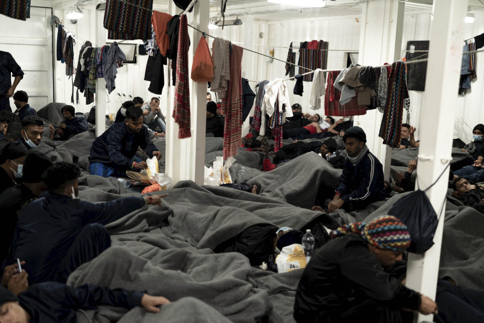 Migrants are wrapped with blankets as they gather on the deck of the Ocean Viking rescue ship, in the Strait of Sicily, in the Mediterranean Sea, Friday, Nov. 4, 2022. (AP Photo/Vincenzo Circosta)