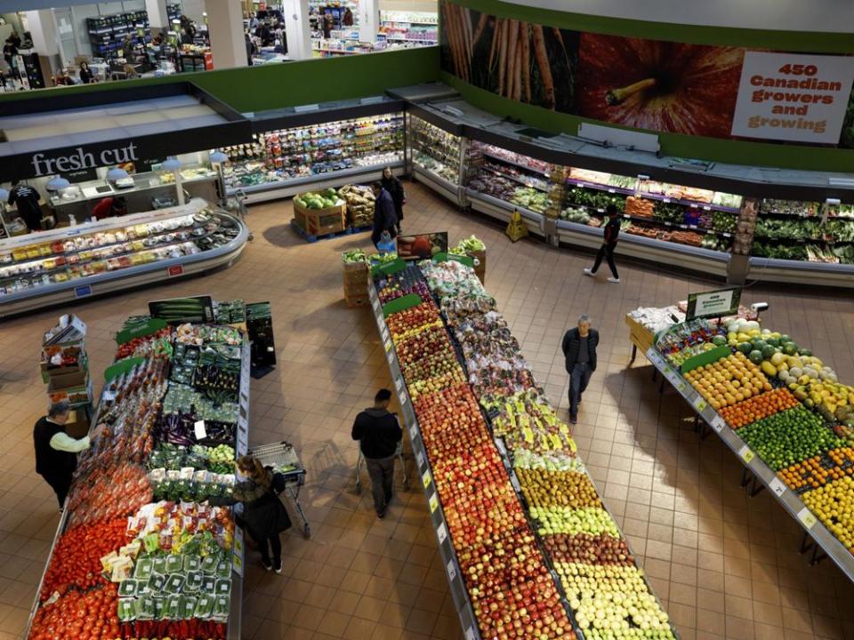  Shoppers browse produce at a Loblaw Cos. grocery store in Toronto.