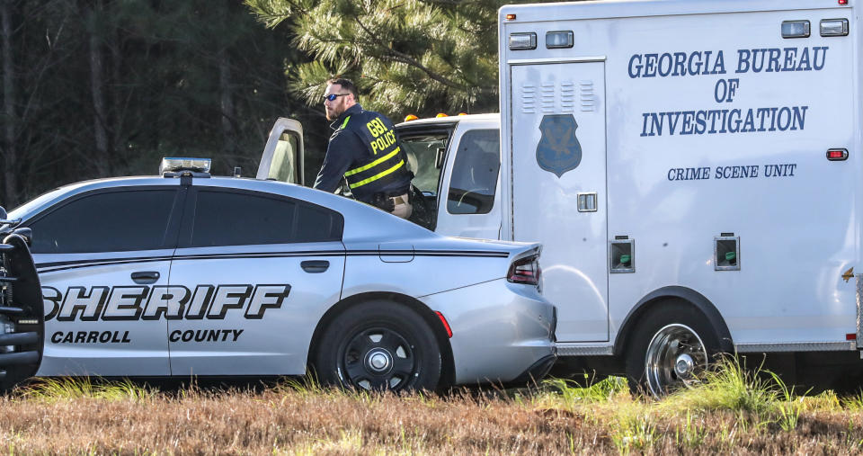 An officer with the Georgia Bureau of Investigation works at the scene following a police chase Monday, April 12, 2021, in Carroll County, Ga. Georgia authorities say multiple officers were injured when the passenger of a car shot them during a police chase that ended with one suspect killed and the other arrested. (John Spink/Atlanta Journal-Constitution via AP)