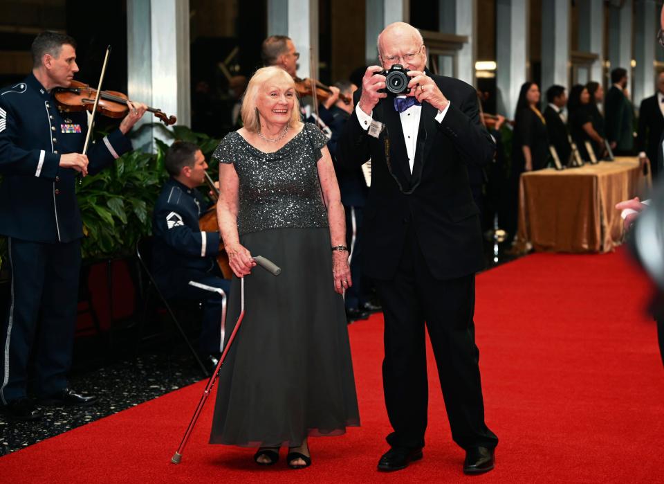 U.S. Sen. Patrick Leahy, D-Vt., lifts his camera to take a photo of the waiting photographers as he arrives with wife, Marcelle Leahy, to the State Department for the Kennedy Center Honors gala dinner, Saturday, Dec. 3, 2022, in Washington.