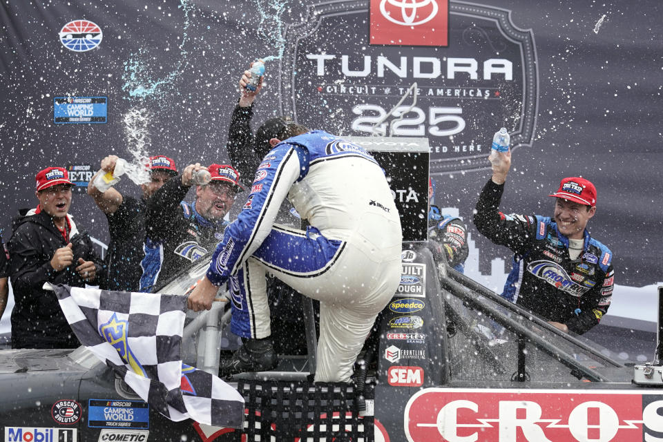 Todd Gilliland celebrates with his crew in Victory Lane after winning the NASCAR Truck Series auto race at the Circuit of the Americas in Austin, Texas, Saturday, May 22, 2021. (AP Photo/Chuck Burton)