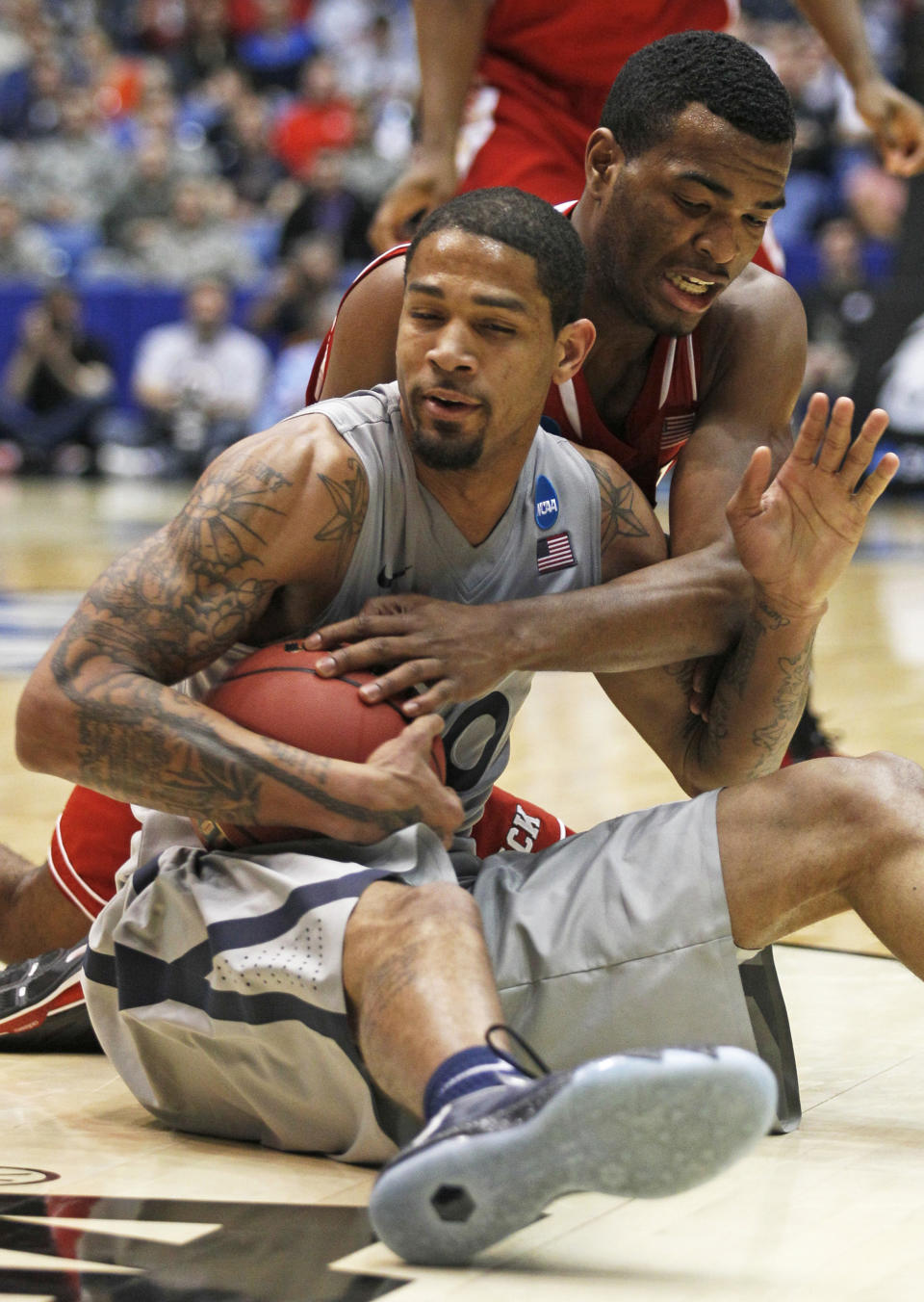 Xavier forward Justin Martin, front, keeps a loose ball away from North Carolina State forward T.J. Warren during the second half of a first-round game of the NCAA college basketball tournament, Tuesday, March 18, 2014, in Dayton, Ohio. (AP Photo/Skip Peterson)