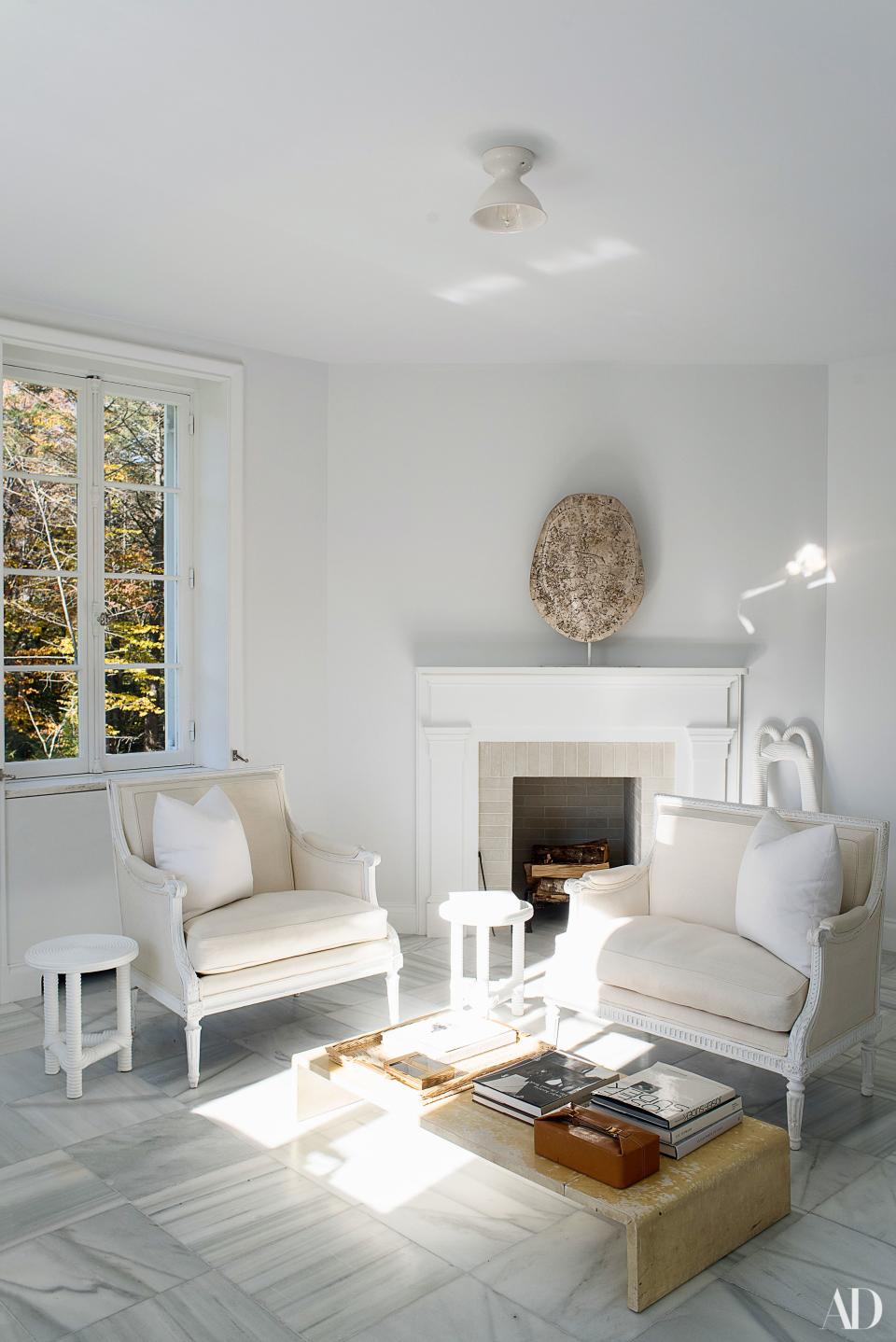 In the master bath, a Jean-Michel Frank parchment waterfall cocktail table sits between a pair of Jacob Frères chairs.