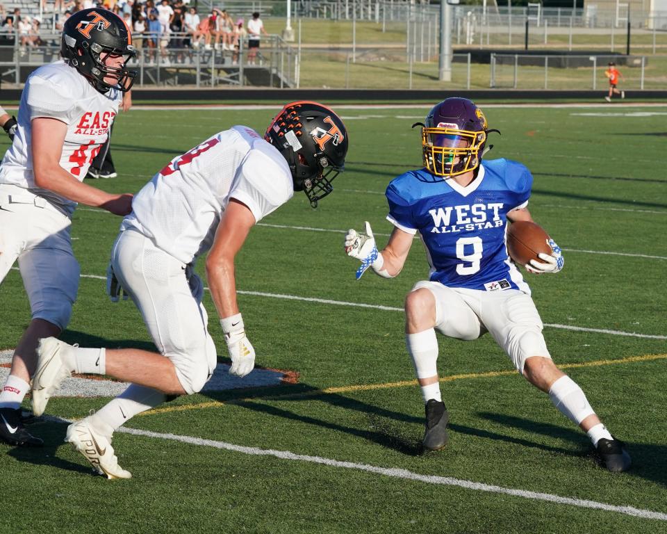 East All-Stars Jayden Amaya and Brandon Rau of Tecumseh swarm to West All-Star Brody Giroux (Onsted) during Friday's Lenawee County Football Senior Showcase at Tecumseh.
