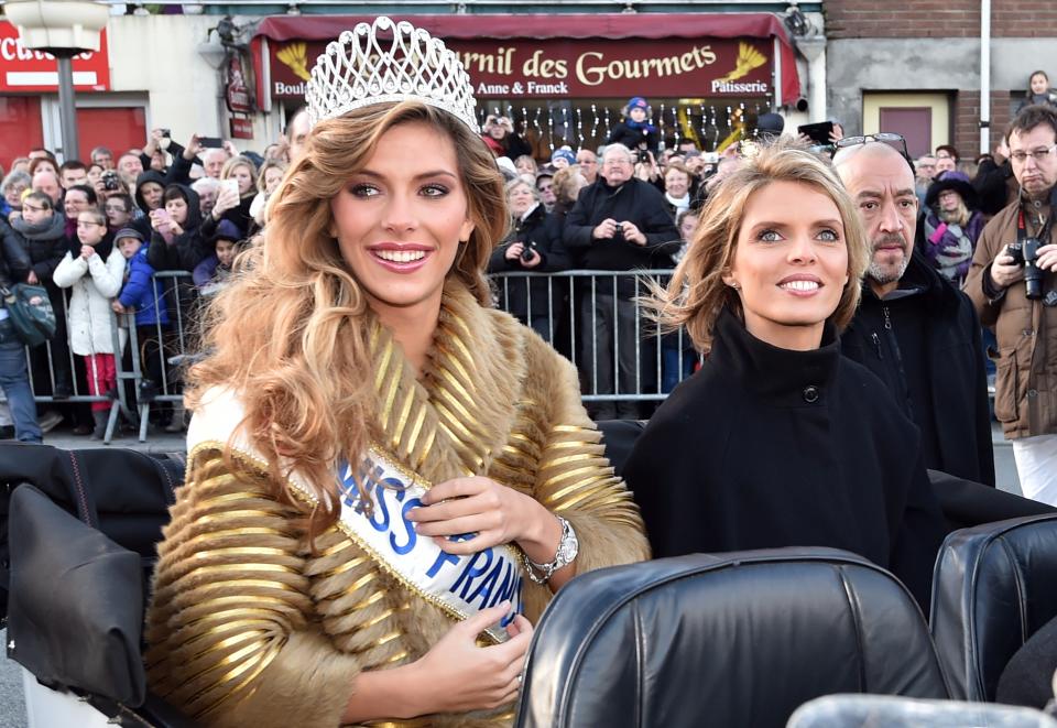 Miss France 2015 Camille Cerf (L) and Miss France society president Sylvie Tellier (R) ride a car during a ceremony for Cerf's return to her hometown of Coulogne, northern France, on December 20, 2014 after winning the Miss France 2015 beauty contest. Miss Nord-Pas-de-Calais Camille Cerf won the Miss France 2015 beauty contest on December 6. AFP PHOTO / PHILIPPE HUGUEN        (Photo credit should read PHILIPPE HUGUEN/AFP via Getty Images)