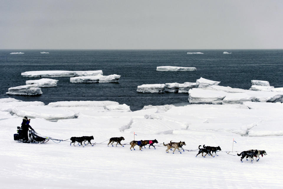 FILE - Jessie Royer passes icebergs in open water on Norton Sound as she approaches Nome, Alaska, in the Iditarod Trail Sled Dog Race, March 13, 2019. Shipping lanes that were once clogged with ice for much of the year along Alaska's western and northern coasts have relented thanks to global warming, and the nation's first deep water Arctic port should be operational in Nome by the end of the decade. (Marc Lester/Anchorage Daily News via AP, File)