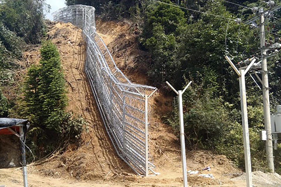 This early 2022 photo provided by Global Witness shows a border fence separating Pangwa in the Kachin state of Myanmar and China. Rare earths imports from Myanmar grew nearly a hundredfold in just the three years since 2015. By 2018, they made up nearly three-fourths of China’s heavy rare-earth-rich clay ore supply, according to the latest statistics available. (Global Witness via AP)