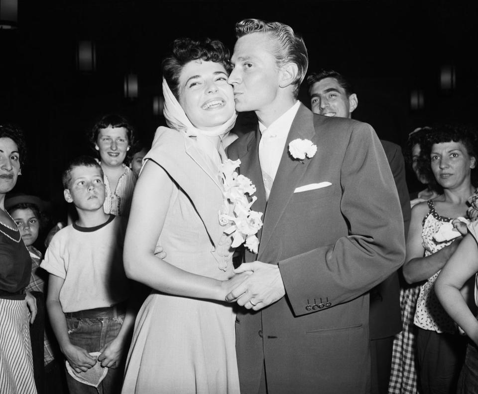 <p>Anne Bancroft tops her bridal look with a white silk headscarf and a flower corsage. The actress married Marty May in August in New York. </p>