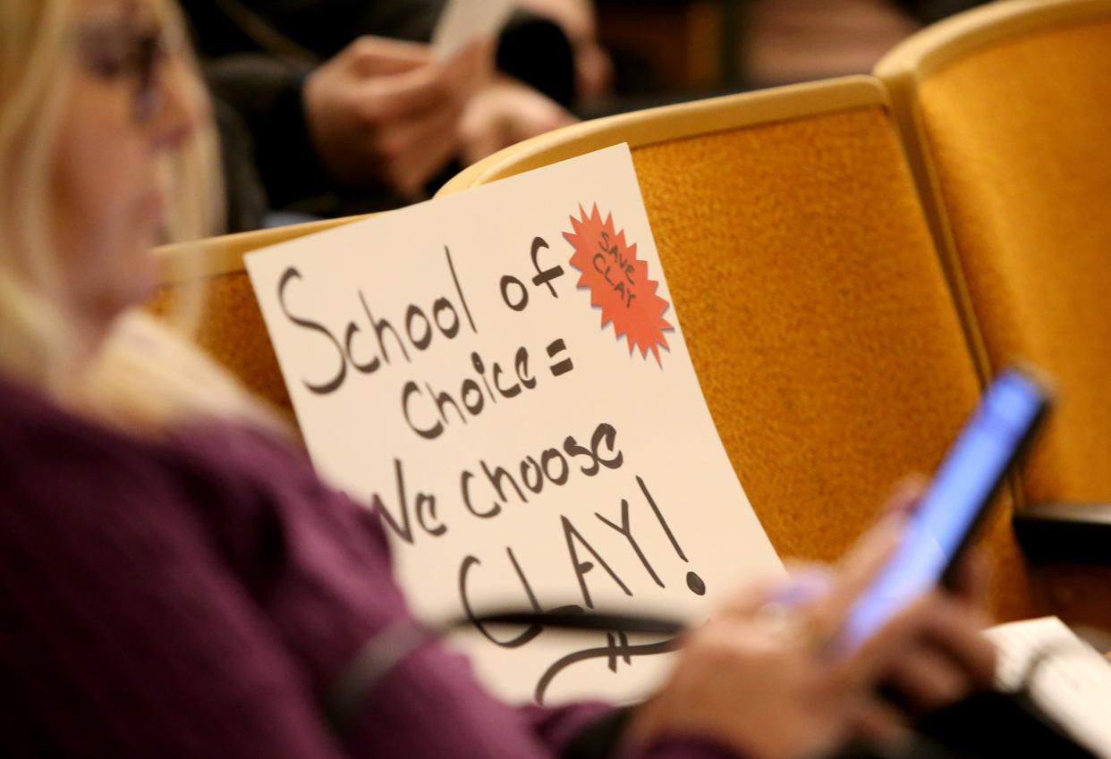 A sign protesting t\any closure of Clay High School sits in a seat at the South Bend school board meeting Monday, March 20, 2023, at Clay High School.  Consultants recommended closure of Clay High School and Warren School in its facilities study findings to the board.