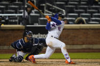 New York Mets' Francisco Lindor follows through on a two-run home run during the seventh inning of a baseball game, next to Atlanta Braves catcher William Contreras on Saturday, May 29, 2021, in New York. (AP Photo/Frank Franklin II)