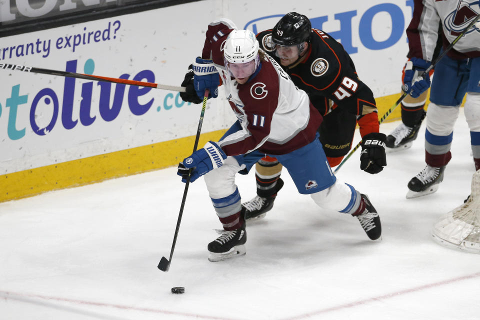 Colorado Avalanche forward Matt Calvert (11) controls the puck next to Anaheim Ducks forward Max Jones (49) during the second period of an NHL hockey game in Anaheim, Calif., Friday, Jan. 22, 2021. (AP Photo/Ringo H.W. Chiu)