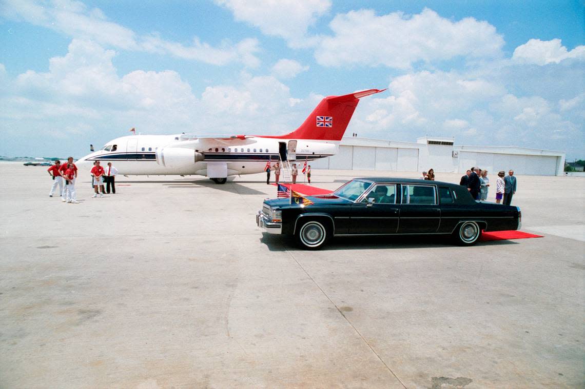 A car carrying Queen Elizabeth at Love Field Airport in Dallas. Mayor Annette Strauss is see in the white blazer and purple skirt at right.