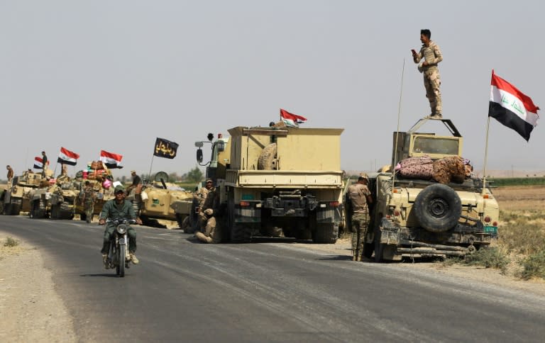 Iraqi forces on the roadside as they head towards Kurdish peshmerga positions on the southern outskirts of Kirkuk