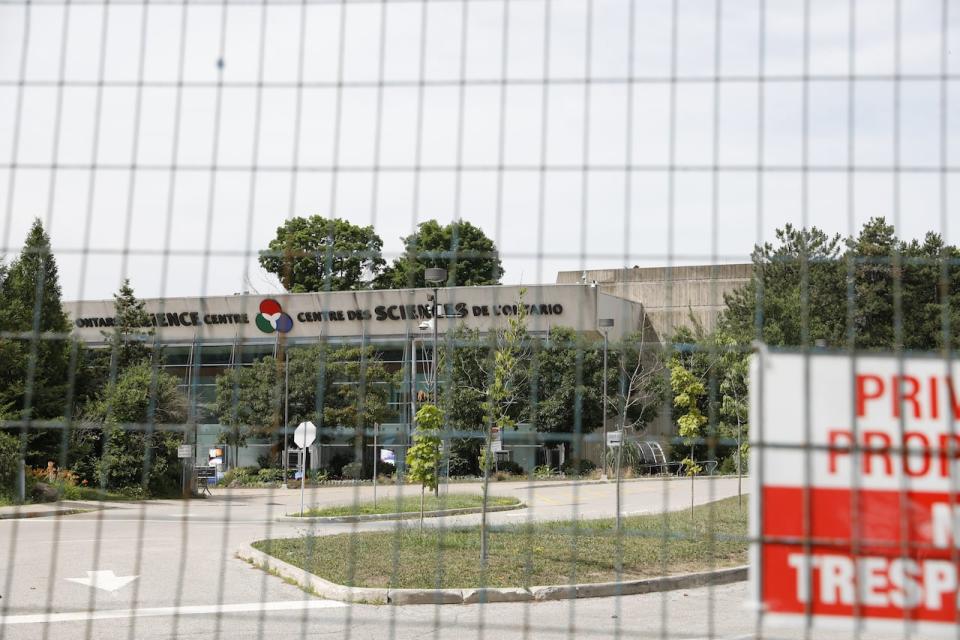 On Wednesday, June 26, 2024, the Ontario Science Centre near Eglinton Avenue East and Don Mills Road is surrounded by a fence on an overcast afternoon after it was abruptly closed the previous Friday.