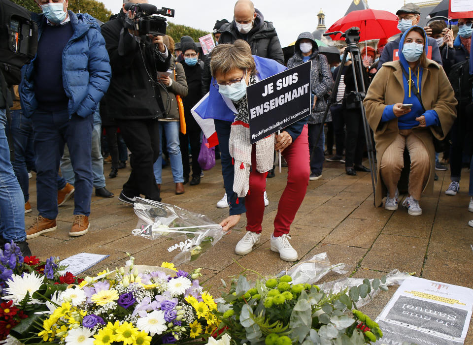 A person holding a a poster that reads: "I am a Teacher", gathers with others on Republique square in Lille, northern France, Sunday Oct. 18, 2020. Demonstrators in France on Sunday took part in gatherings in support of freedom of speech and in tribute to a history teacher who was beheaded near Paris after discussing caricatures of Islam’s Prophet Muhammad with his class. (AP Photo/Michel Spingler)