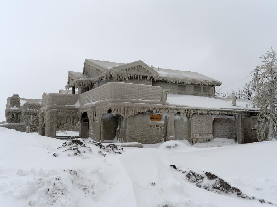 Homes are covered with ice after being battered with waves from Lake Erie along Hoover Beach on December 27, 2022 in Hamburg, New York.