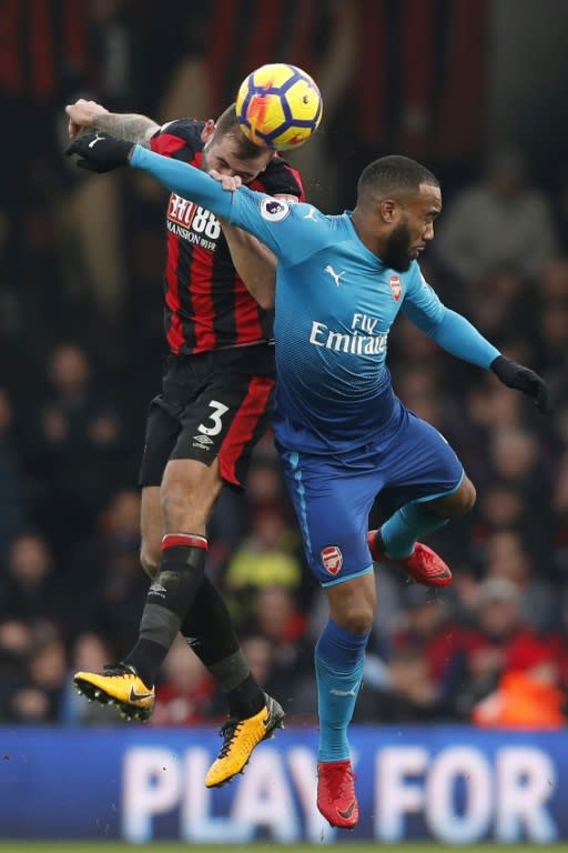 Bournemouth's defender Steve Cook (L) jumps for the ball with Arsenal's striker Alexandre Lacazette on January 14, 2018