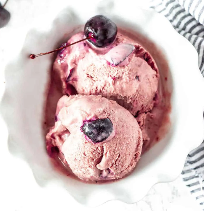 a bowl of ice cream with cherries in it