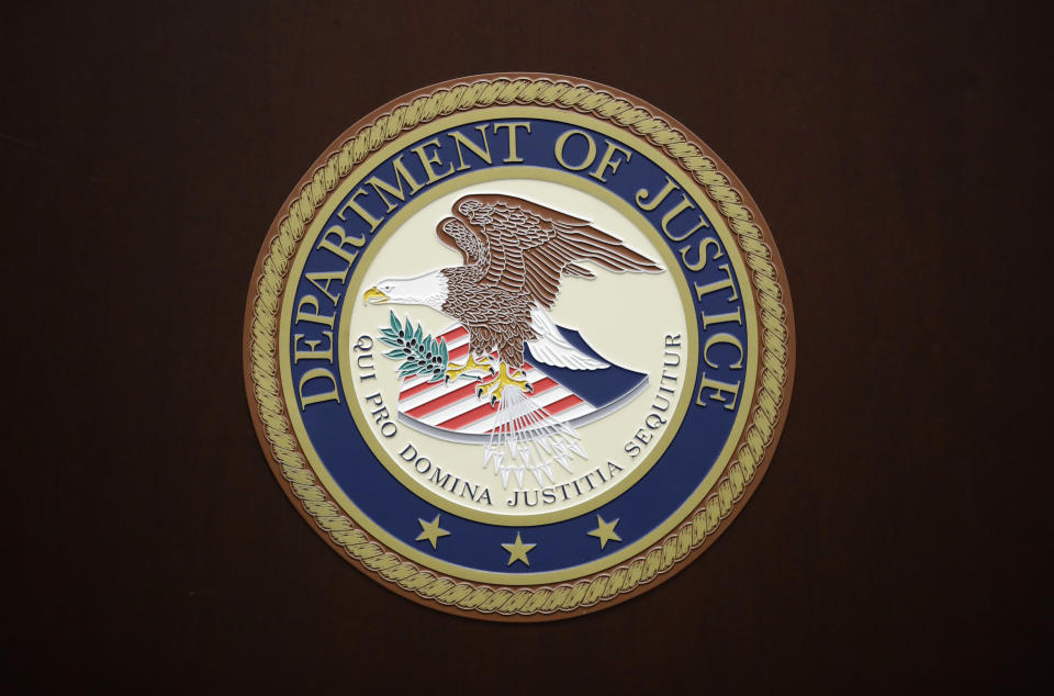 FILE - The U.S. Department of Justice logo is seen on a podium following a news conference in the office of the U.S. Attorney for the District of Maryland in Baltimore, March 1, 2017. On Thursday, Aug. 24, 2023, the U.S. Department of Justice filed suit against SpaceX, the rocket company founded and run by Elon Musk, for alleged hiring discrimination against refugees and people seeking or already granted asylum. (AP Photo/Patrick Semansky, File)