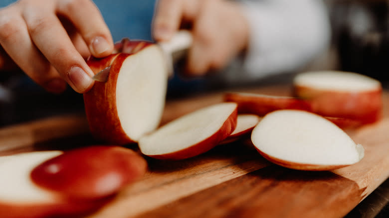 Person slicing apple