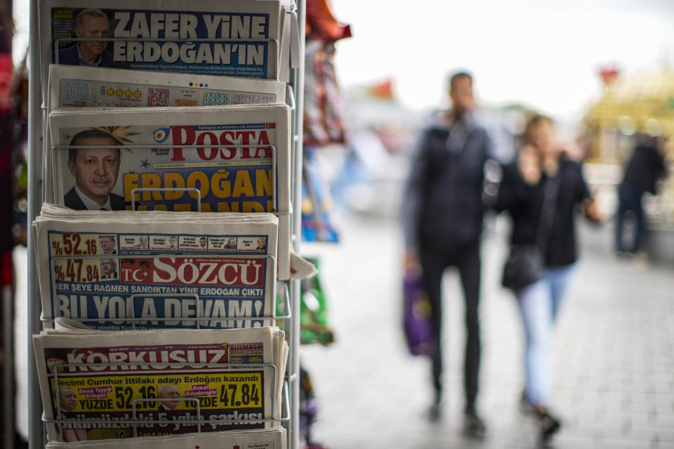 People walk past a rack with Turkish newspapers a day after the presidential election day in Istanbul, Monday, May 29, 2023. Turkish President Recep Tayyip Erdogan has dissipated a challenge by an opponent who sought to reverse his increasingly authoritarian leanings, securing five more years to oversee the country at the crossroads of Europe and Asia that plays a key role in NATO. (AP Photo/Emrah Gurel)