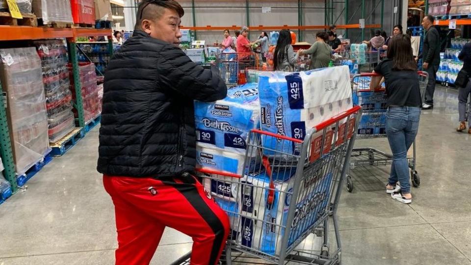 Un hombre con cinco paquetes grandes de papel higiénico en California. ¿Estás acumulando papel higiénico en tu casa? ¿Te has puesto a pensar si realmente lo necesitas? Foto: Getty Images. 