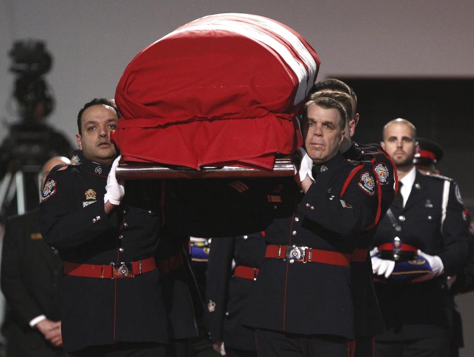 The honor guard carries the casket into the public memorial for police constable John Zivcic in Toronto