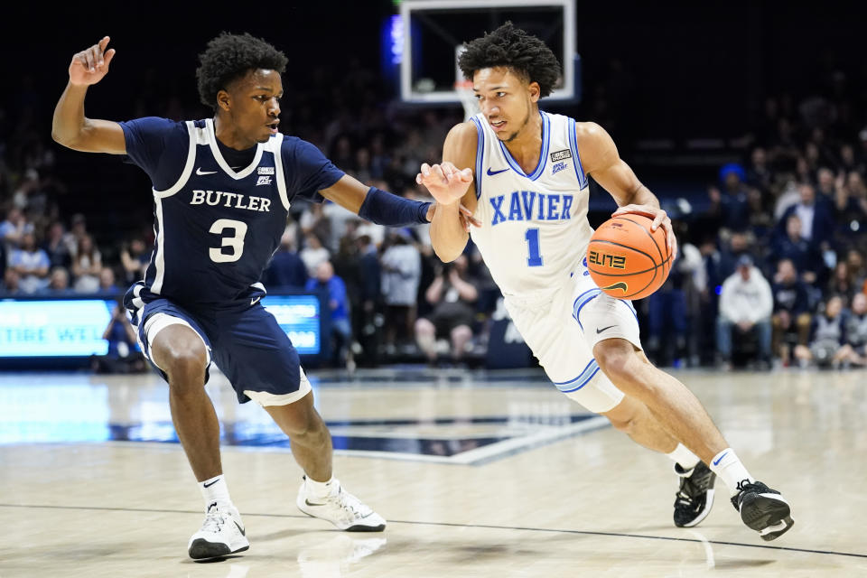 Xavier guard Desmond Claude (1) drives to the basket as Butler guard Chuck Harris (3) defends during the second half of an NCAA college basketball game, Saturday, March 4, 2023, in Cincinnati. (AP Photo/Joshua A. Bickel)