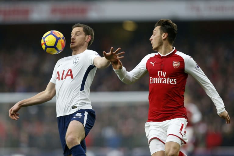 Tottenham Hotspur's Jan Vertonghen holds off Arsenal's Mesut Ozil during their Premier League match at the Emirates Stadium on November 18, 2017