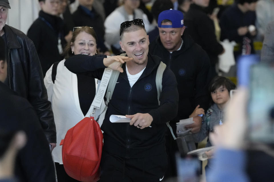 Los Angeles Dodgers Enrique Hernandez, center, and Miguel Rojas, center right, walk through a terminal during the baseball team's arrival at Incheon International Airport, Friday, March 15, 2024, in Incheon, South Korea, ahead of the team's baseball series against the San Diego Padres. (AP Photo/Ahn Young-joon)