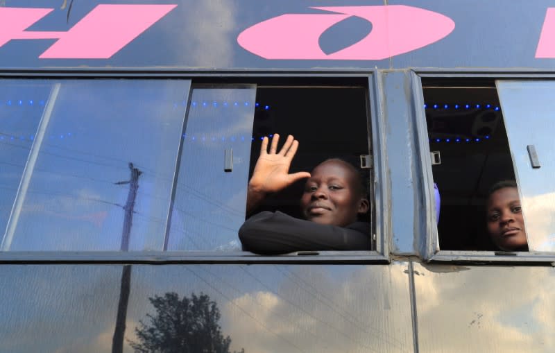 A passenger waves as she sits in a disinfected public transport bus as residents leave for the villages amid concerns over the spread of coronavirus disease (COVID-19) in Nairobi