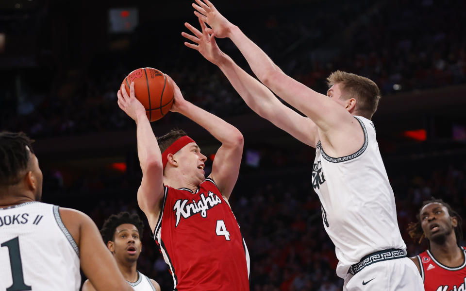 Rutgers guard Paul Mulcahy (4) drives to the basket against Michigan State forward Jaxon Kohler (0) during the first half of an NCAA college basketball game in New York, Saturday, Feb. 4, 2023. (AP Photo/Noah K. Murray)