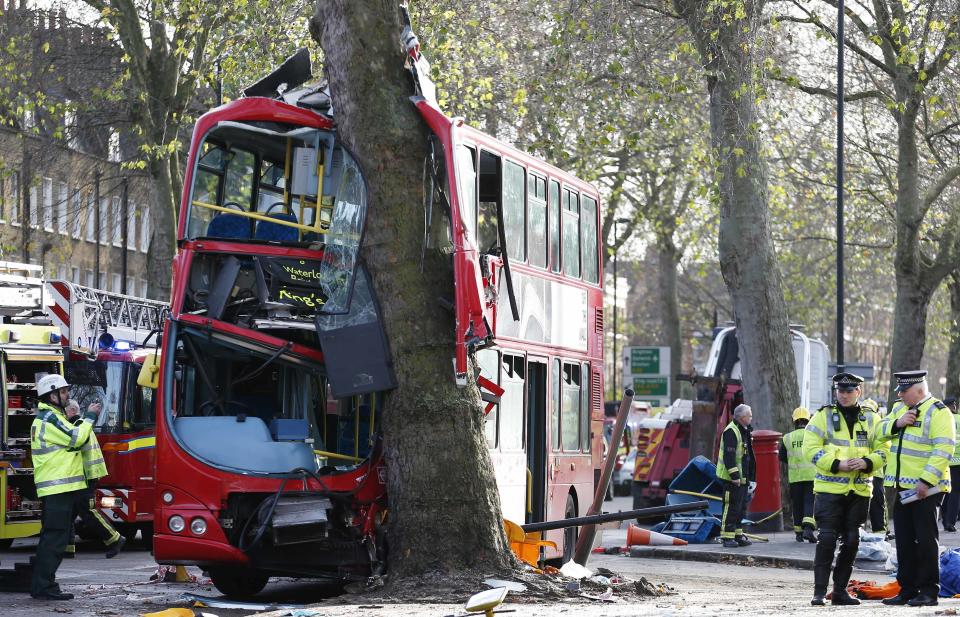 Members of the emergency services attend to a bus which crashed into a tree in Kennington, south London