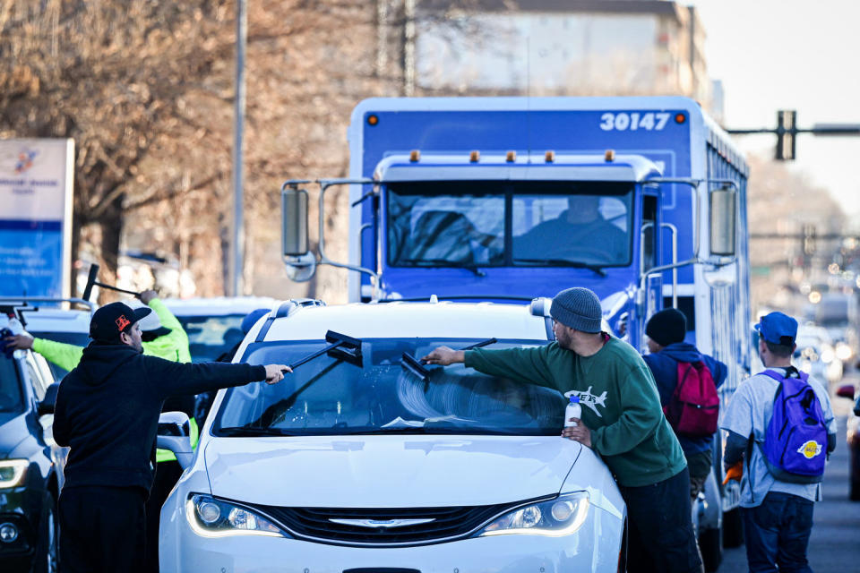 Migrants try to make money by cleaning windshields of drivers at stoplights. (Helen H. Richardson / MediaNews Group / The Denver Post via Getty Images file)